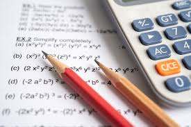 Calculator with pencils and mathematical equations on paper, representing beauty tax calculations