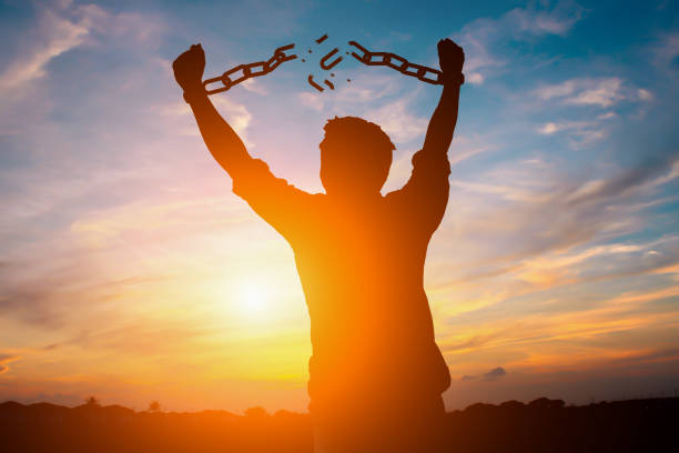 Silhouette of person breaking free from chains, symbolizing freedom from appearance-based injustice